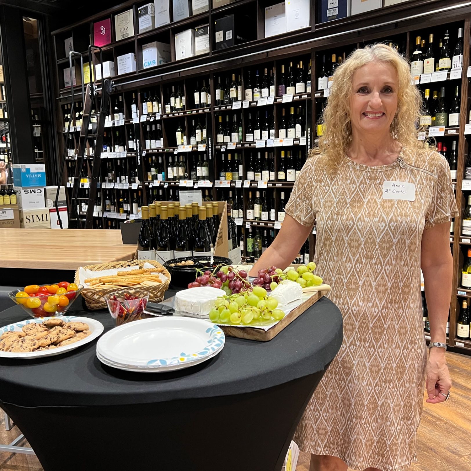 woman standing next to appetizers in a wine cave